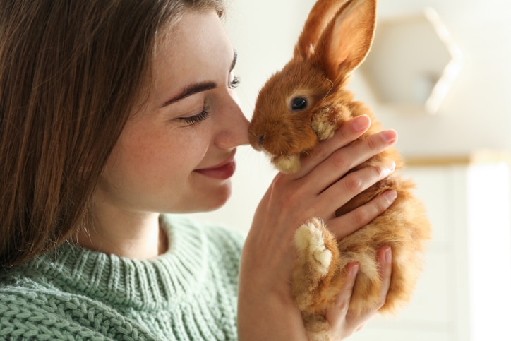 best rabbit gifts; a pet parent holds her rabbit lovingly.