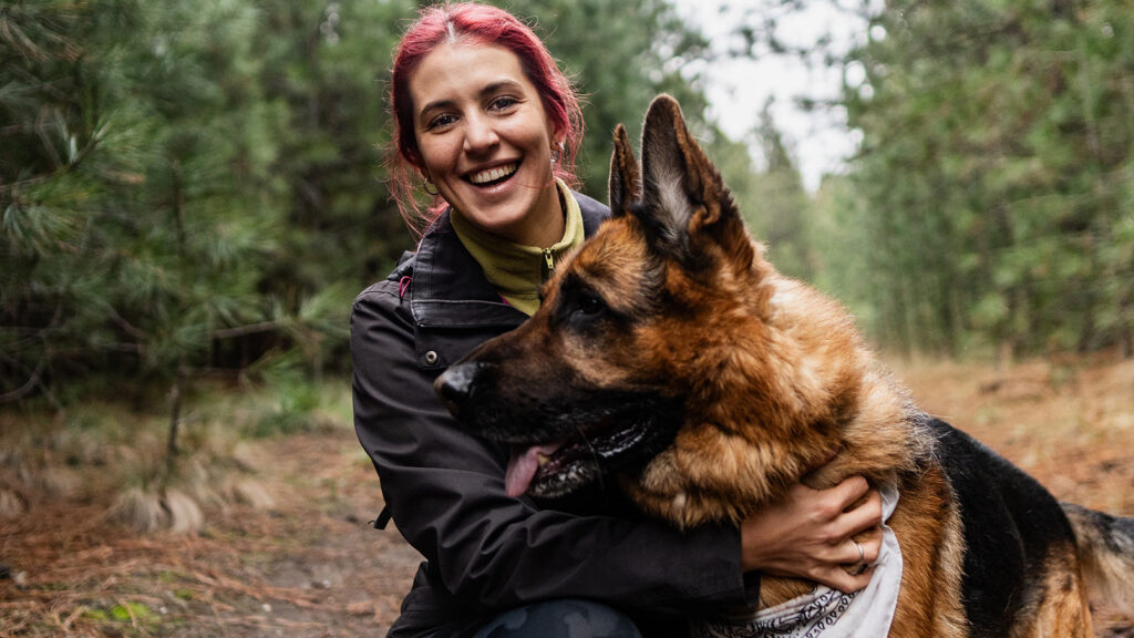 A hiker embracing her dog on a hike