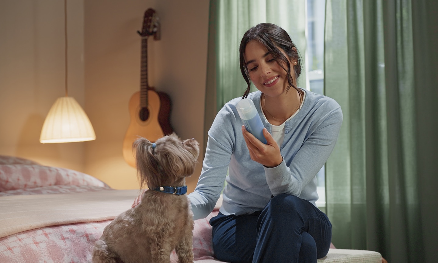 A woman preparing to use tear stain remover on her dog