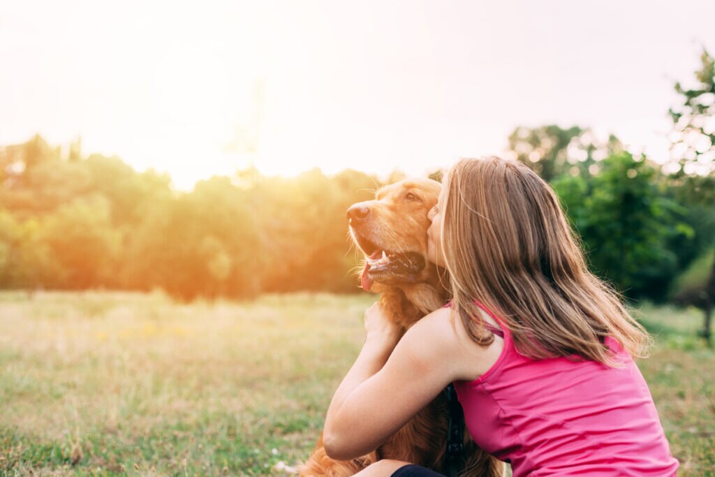 girl-hugging-senior-dog-in-field