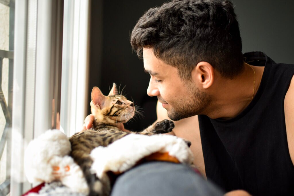 man-leaning-face-to-cat-face