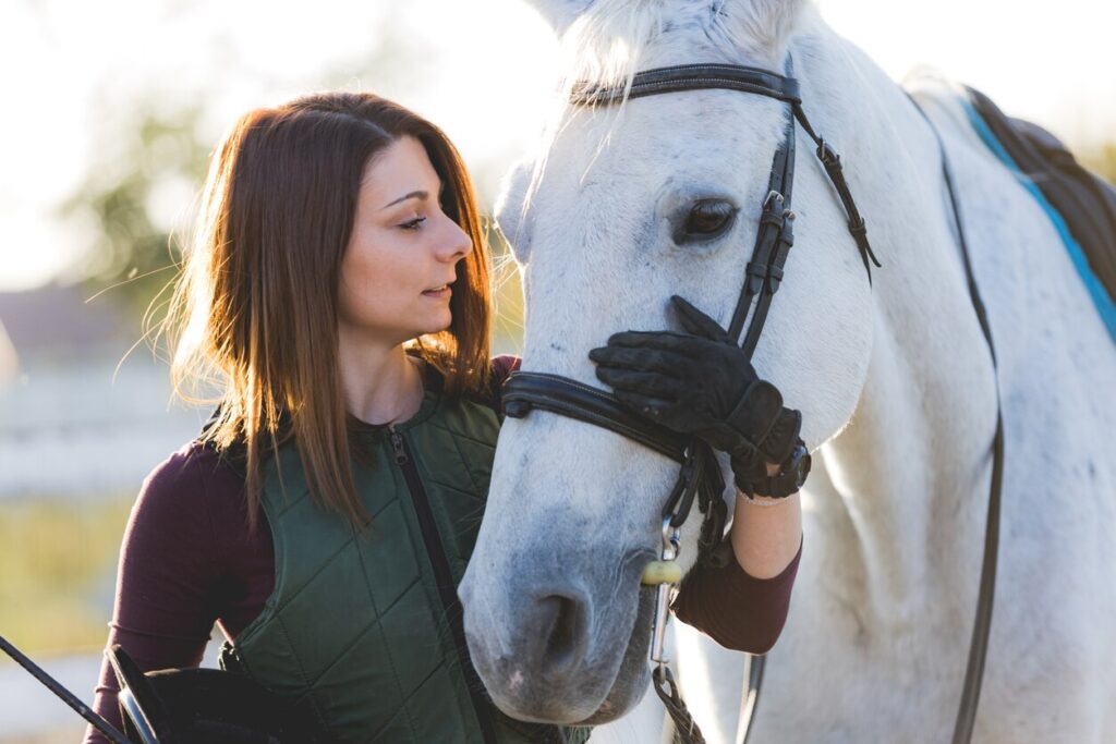 woman-holding-muzzle-of-horse