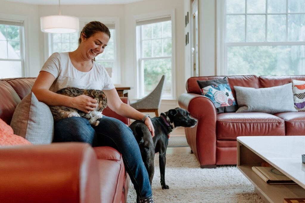 woman-sitting-with-dog-and-cat