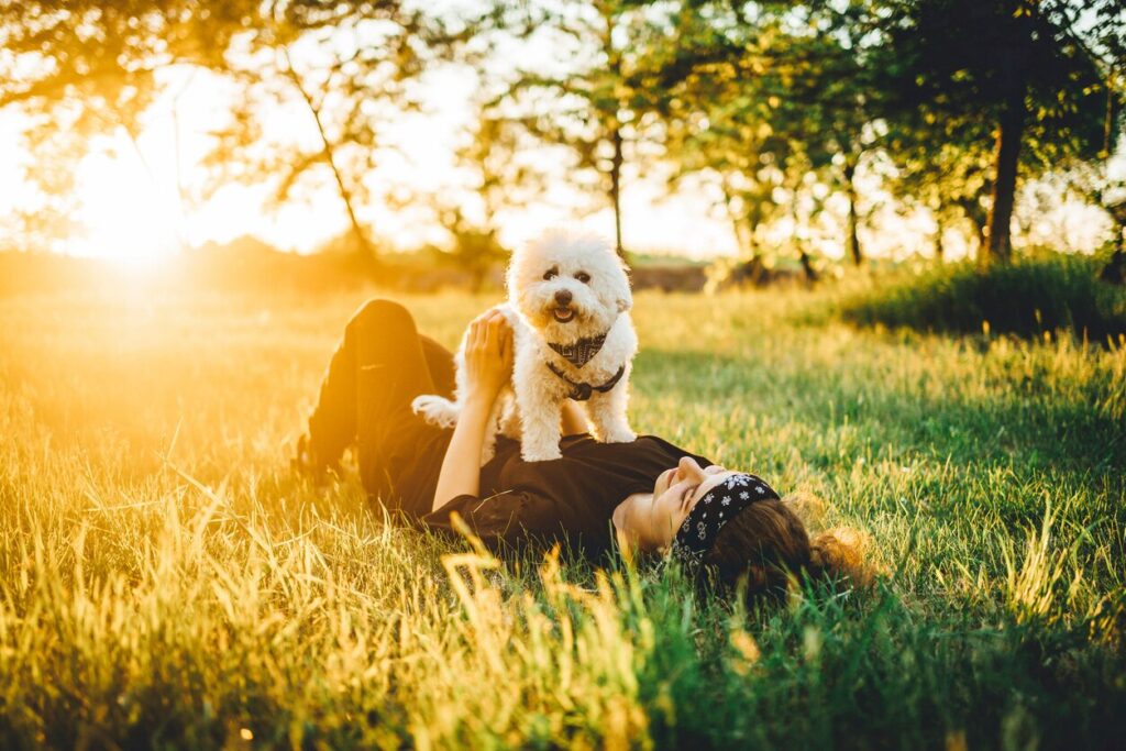 woman-lying-in-grass-with-dog-on-chest