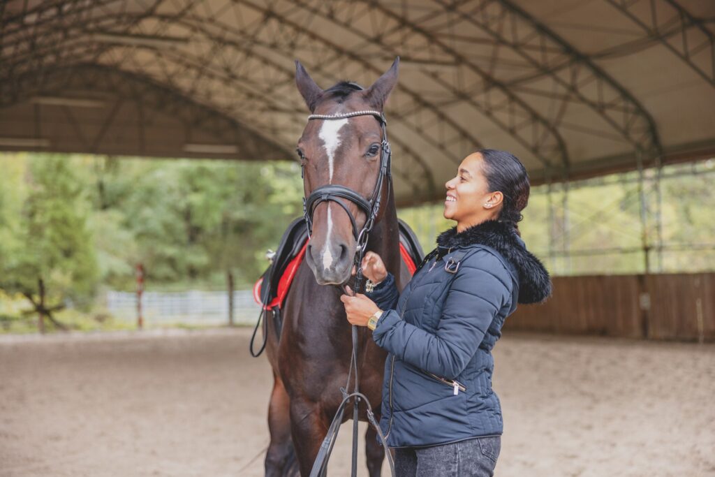 woman standing with horse in ring