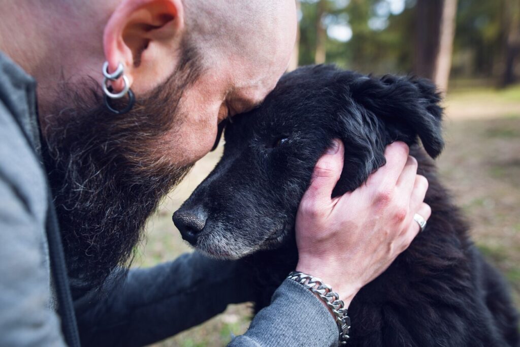 man-holding-black-lab-dog-face-to-his-face