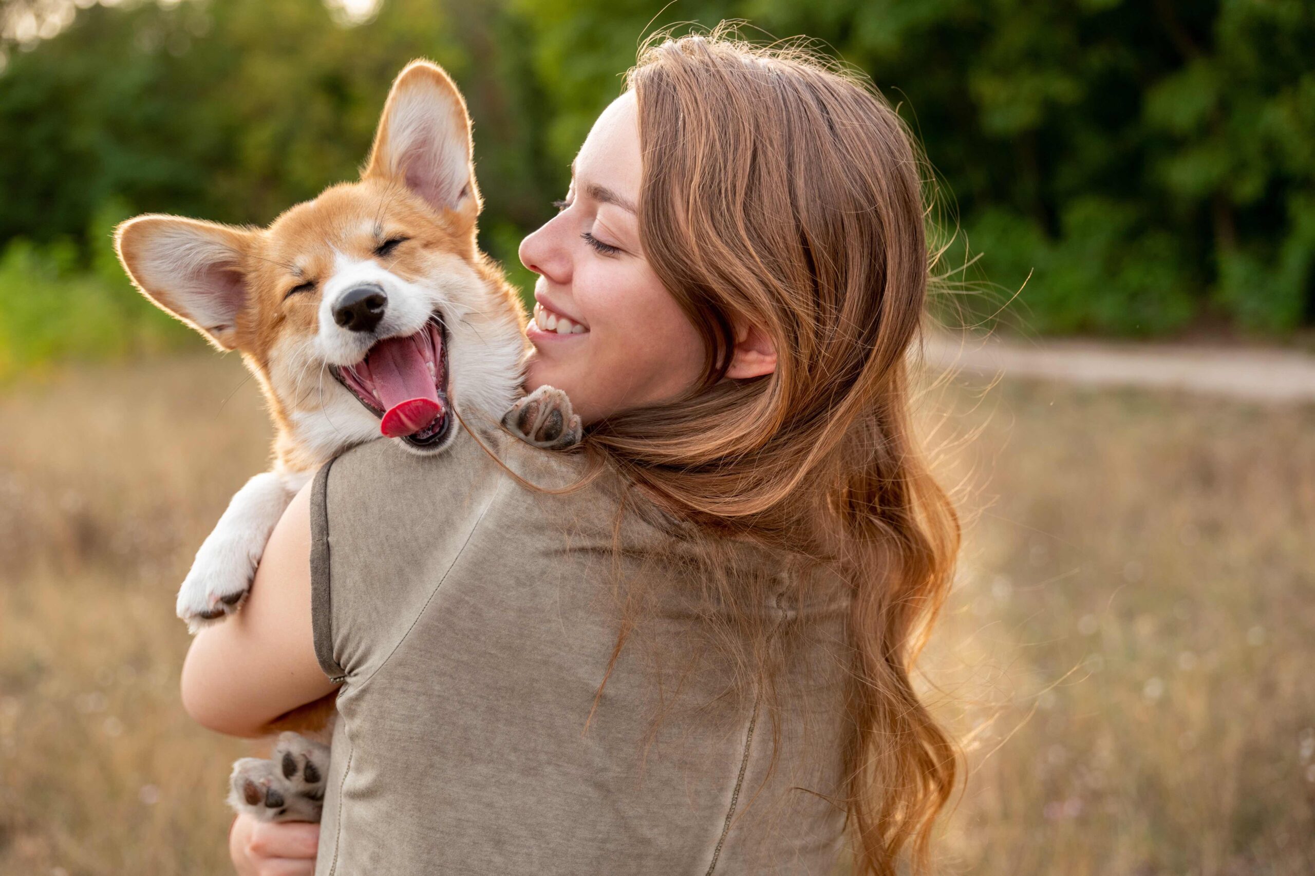 woman holding a yawning corgi