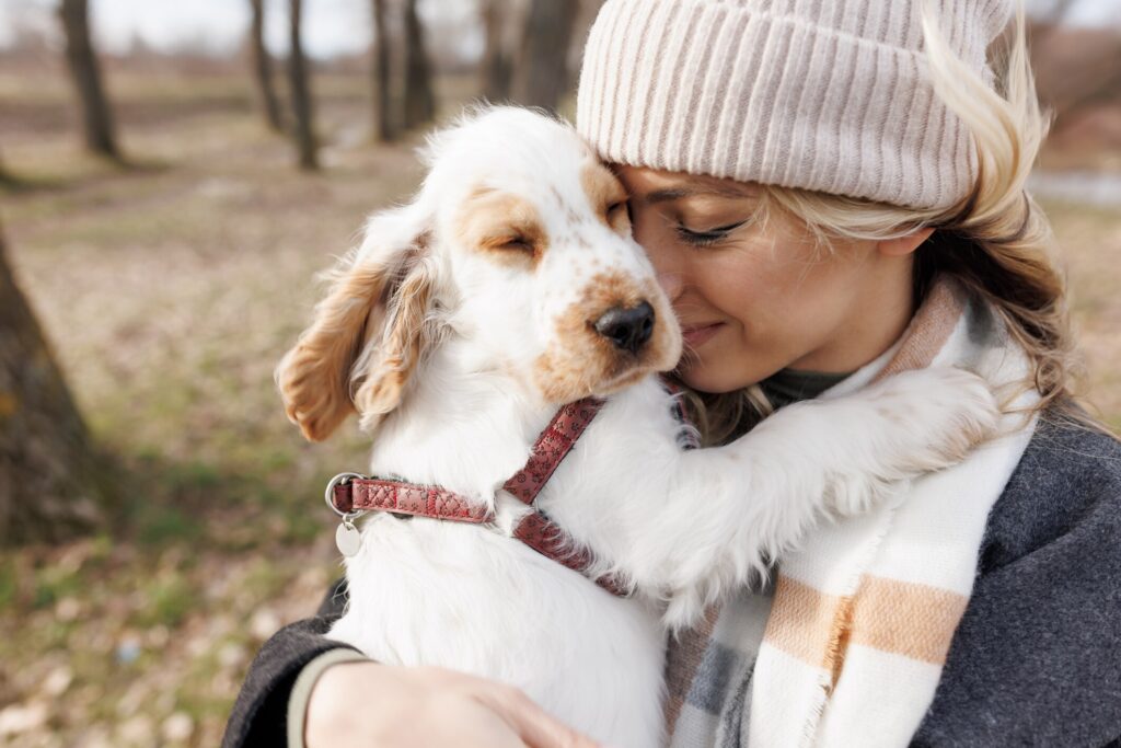 A pet parent hugs her puppy.
