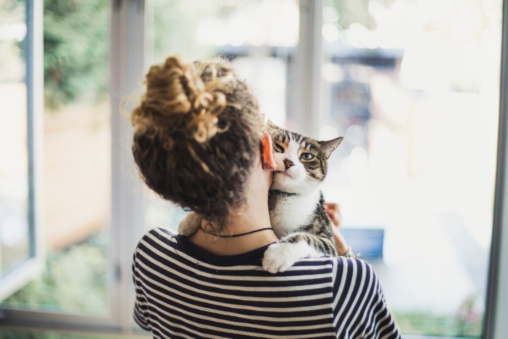 woman snuggling with cat