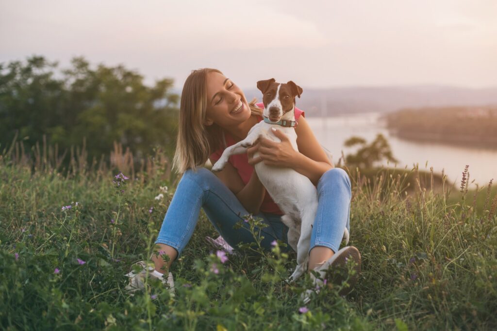A pet parent hugs her dog.