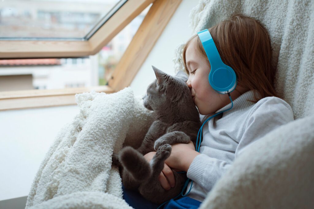 A cat sits with his family member by a window.