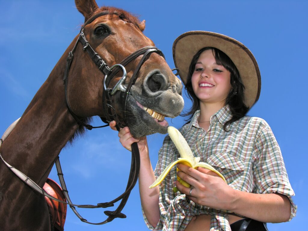 girl sharing a banana with her horse