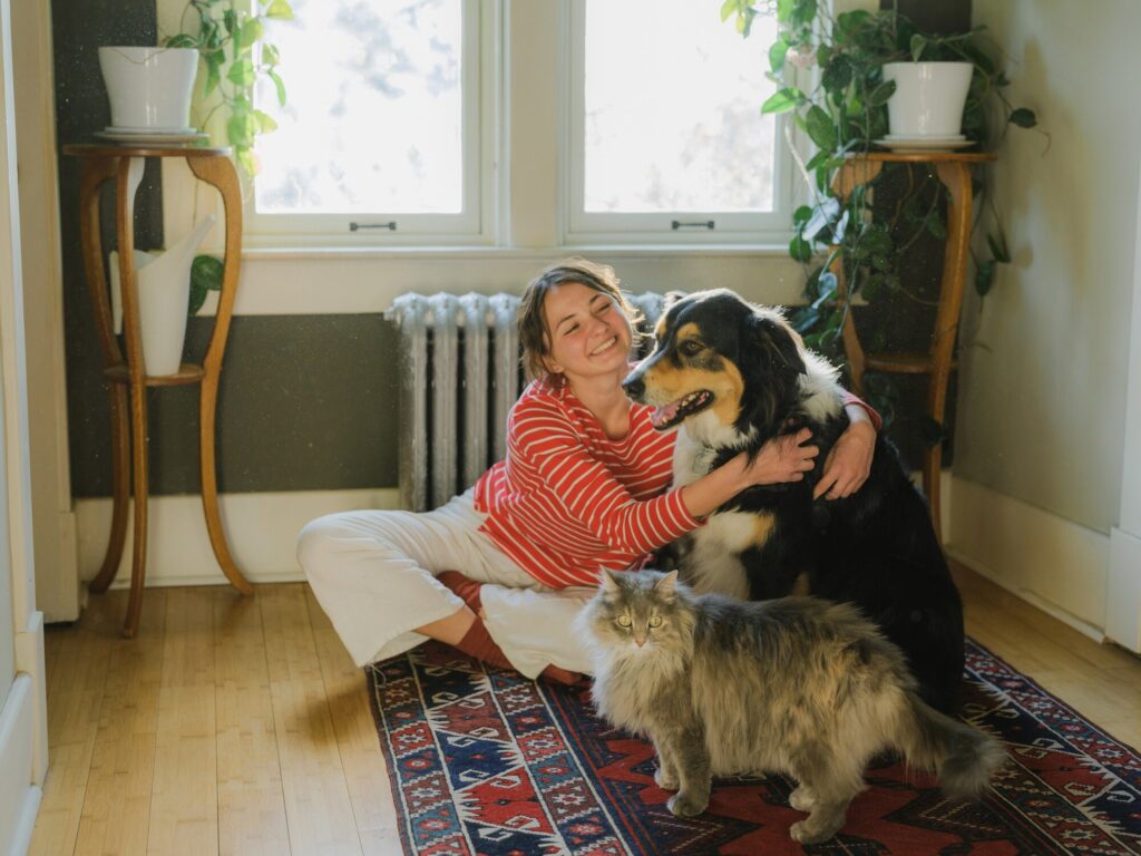 myths about heartworms; woman with dog and cat sitting on living room floor