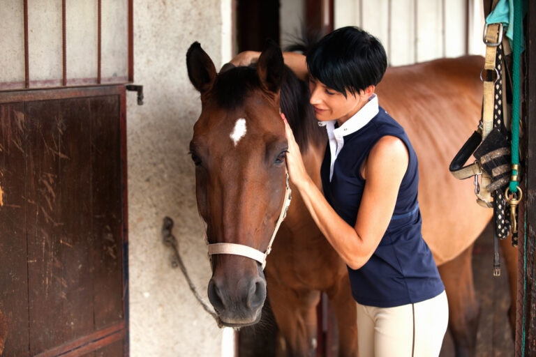 Woman petting her horse affectionately