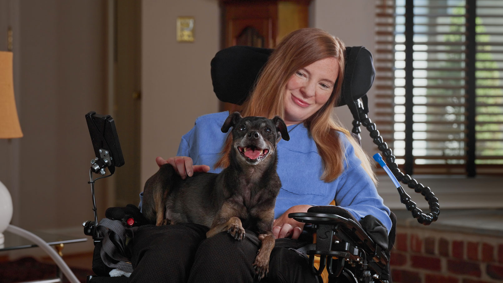 Brooke Eby and her dog Dray sitting together in their home
