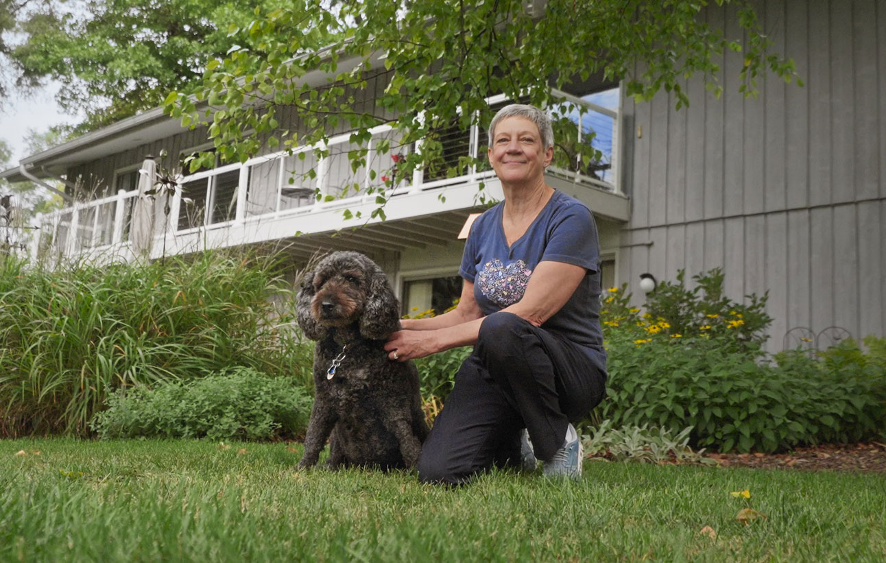 Taylor the therapy dog poses with her pet parent Laura outside their home