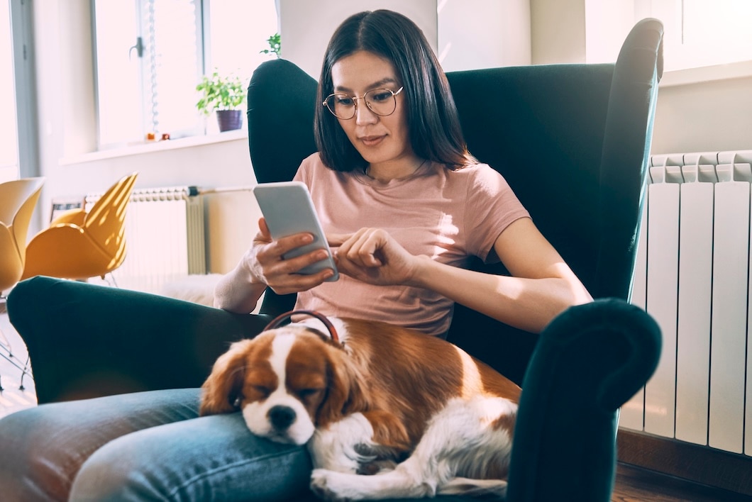 Young woman relaxing with her Cavalier King Charles Spaniel.