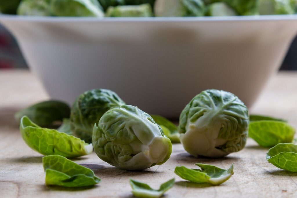 close-up of raw brussels sprouts in front of a white bowl