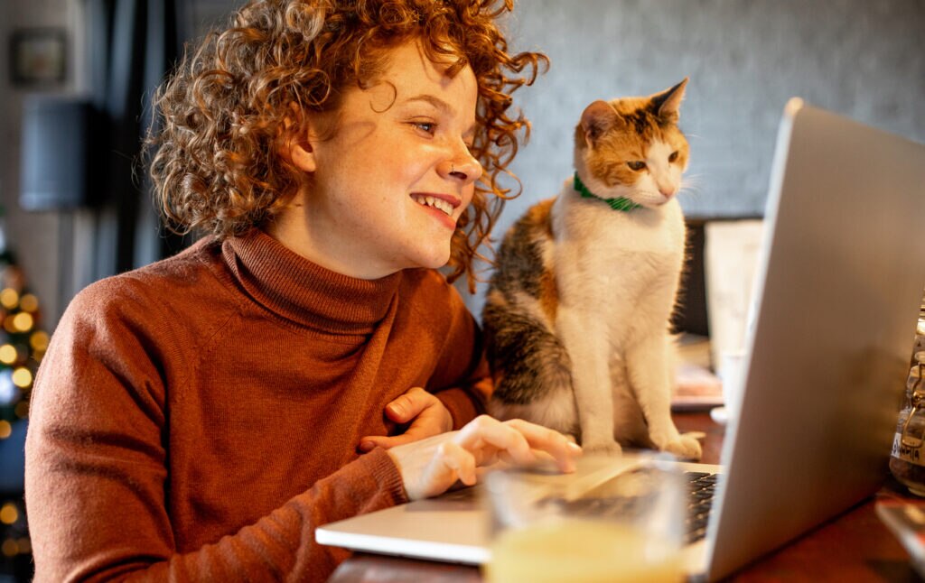 woman and cat looking at computer screen together