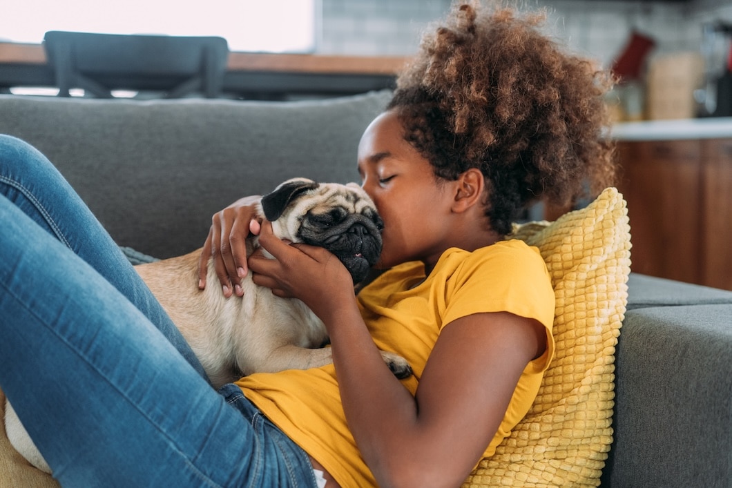 Girl sitting on a sofa with her dog at home